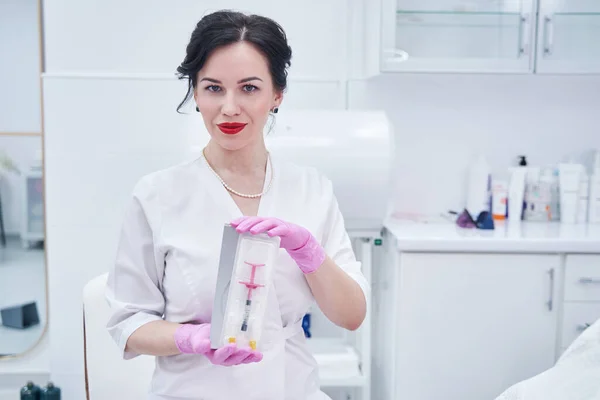 Kobieta kosmetyczka ze strzykawką kosmetyczną stojąca w salonie piękności — Zdjęcie stockowe