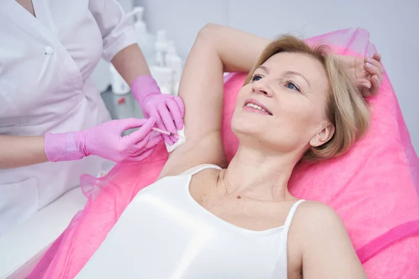 Mujer recibiendo inyección de axila en salón de belleza —  Fotos de Stock