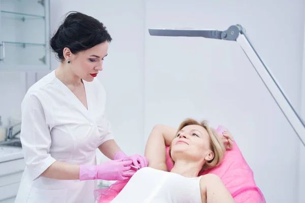 美容外科诊所接受腋下注射的妇女 — 图库照片