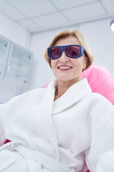 Mujer feliz en gafas de seguridad descansando en el salón de belleza — Foto de Stock
