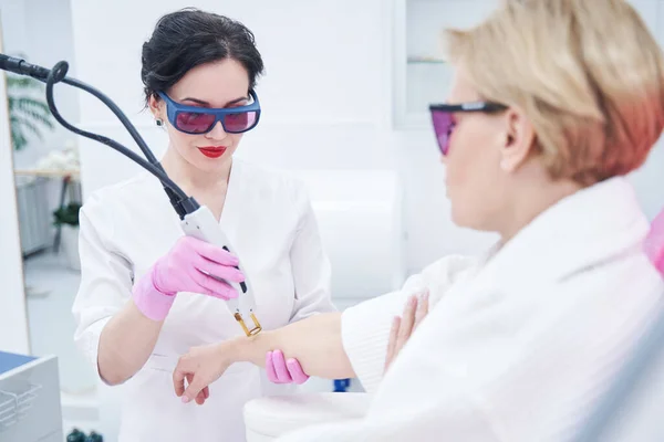 Mujer adulta que recibe tratamiento de depilación láser en clínica de belleza — Foto de Stock