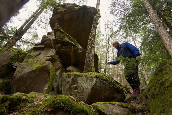 Yürüyüş sırasında yosunlu taşlardan inen erkek