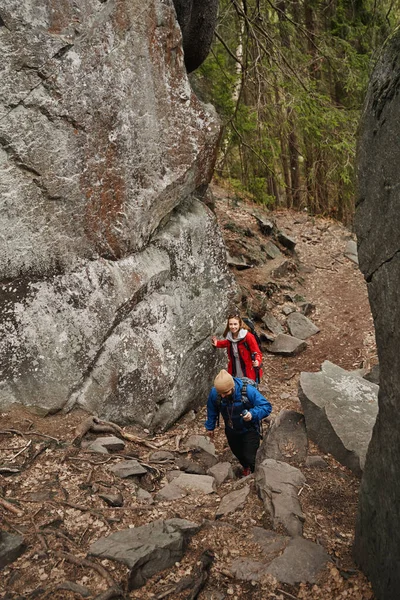 Bir çift turist ormanda kayalık patikaya çıkıyorlar.