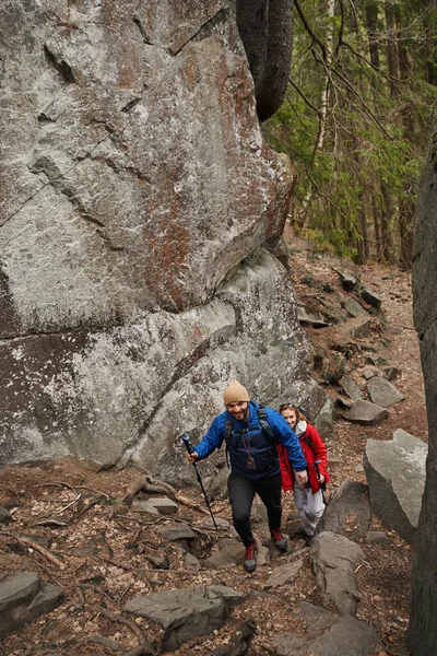Sırt çantaları İskandinav direkleriyle köy yolunda yürüyor