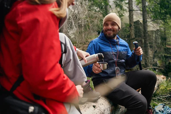 Minnettar adam termosunu dolduran turist kadına bakıyor.