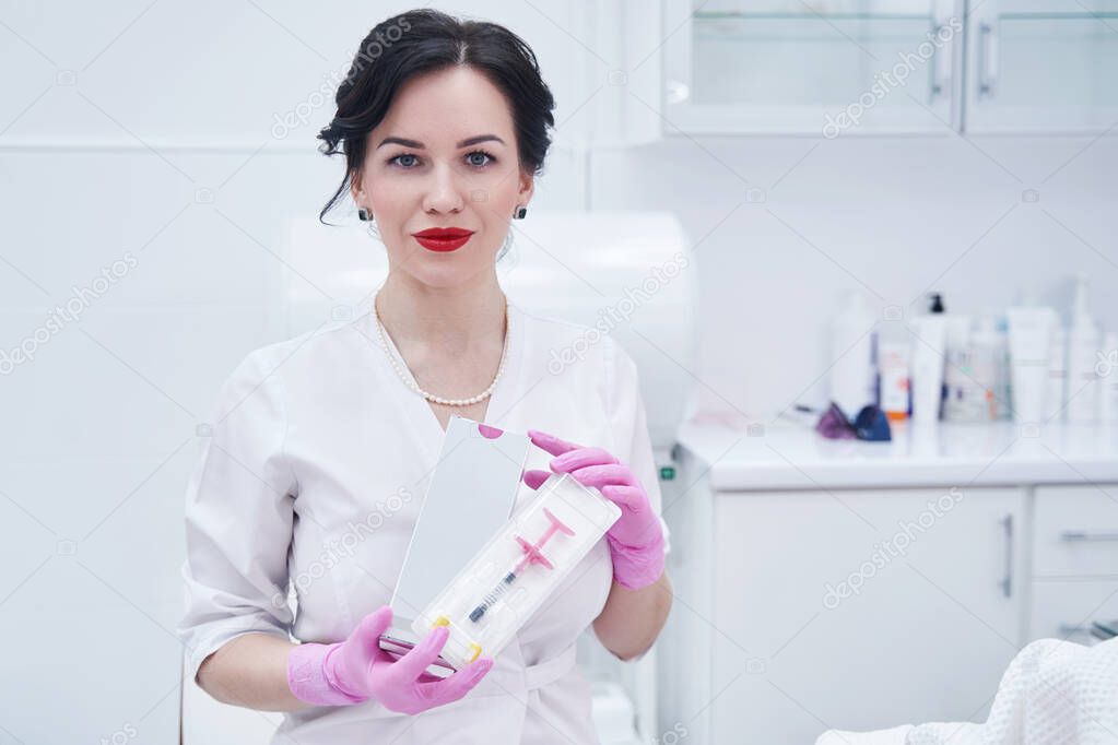 Woman beautician with cosmetic syringe standing in beauty salon