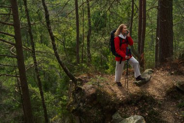 Gezgin sırt çantasıyla yürürken telefonla konuşuyor.