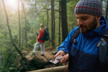 Ormanda seyrüsefer için pusula kullanan erkek turist