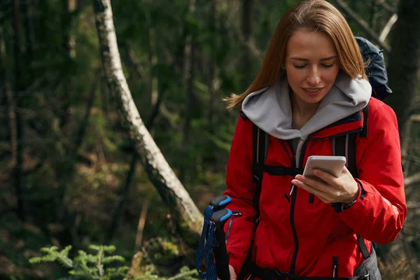 숲 속을 하이킹하면서 스마트폰으로 문자 메시지를 보내는 도보 여행자들 — 스톡 사진