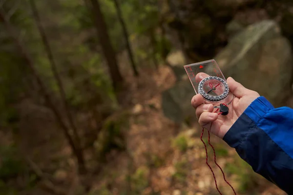 Tourist navigating with help of compass in forest — Stock Photo, Image
