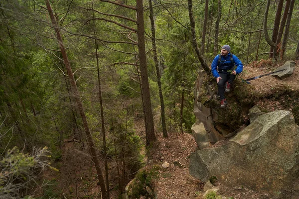 쉬는 시간에 숲 속의 바위 위에 앉아 있는 수컷 트레커 — 스톡 사진
