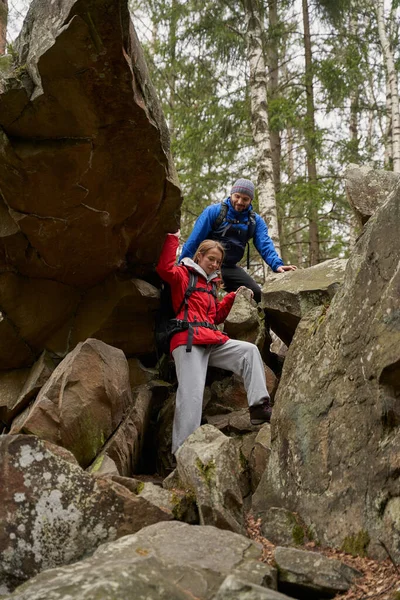 Randonnée femelle escalade les pierres avec le soutien de l'homme — Photo