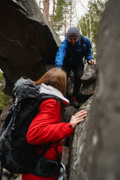 긍정적 인 관광 안내원의 도움을 받는 여자가 등산 로를 지나기 어려운 지역을 지나다 — 스톡 사진