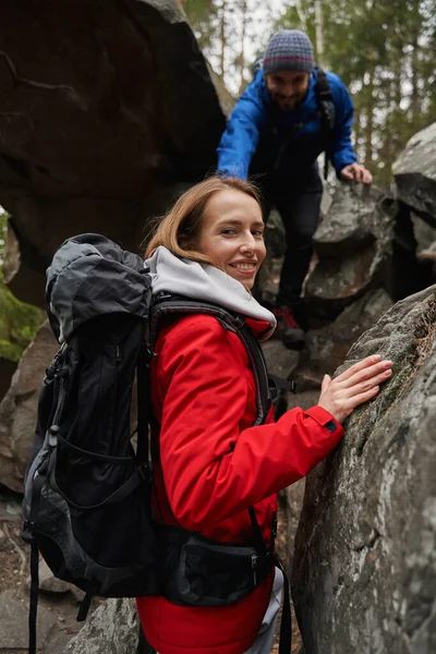 Happy woman foot traveller getting help from man in climbing — Stockfoto