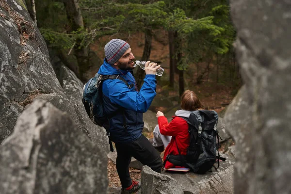 Tourist making a sip from bottle during hiking tour — 스톡 사진