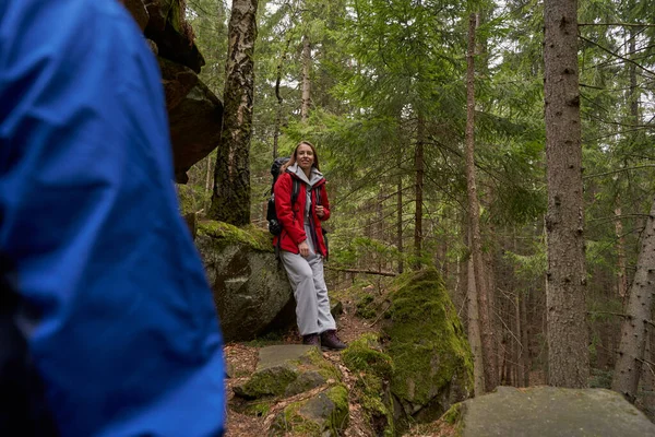 Yürüyüşçü kayaya yaslanmış, arkadaşını izliyor.
