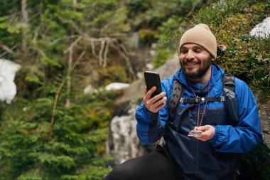 Yakışıklı yürüyüşçü macerası sırasında video çekiyor.