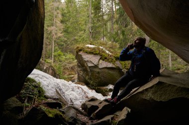 Yorgun bir erkek taşın üzerinde dinleniyor.
