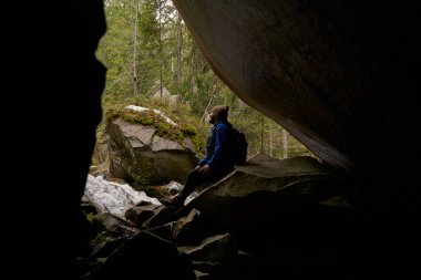Düşünceli gezgin, manzaralı dağ manzarasına bakıyor.