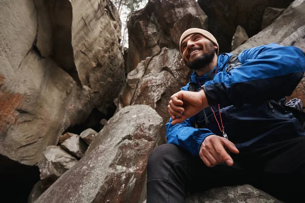 바위 위에서 휴식을 취하는 긍정적 인 즐거움을 주는 등산객 — 스톡 사진