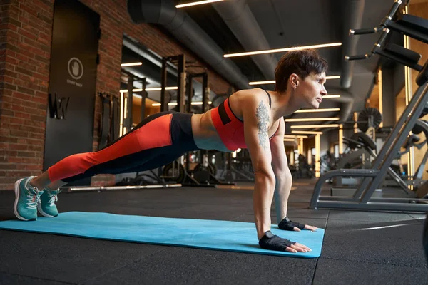Passform kvinna gör core motion på gym — Stockfoto