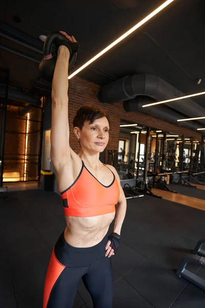 Mujer atlética realizando ejercicio de levantamiento de pesas en el gimnasio — Foto de Stock