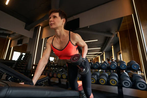 Mujer haciendo ejercicio de mancuerna soltera en el gimnasio — Foto de Stock