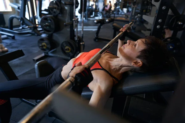 Ejercicio profesional femenino de levantamiento de pesas en gimnasio — Foto de Stock