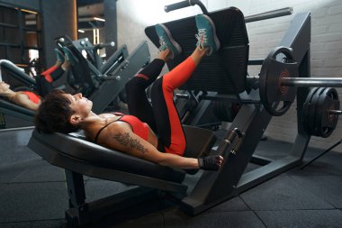 Sporcu kadın fitness kulübünde egzersiz yapıyor.