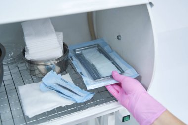 Sterilizasyondan sonra enstrümanları alan sağlık çalışanı