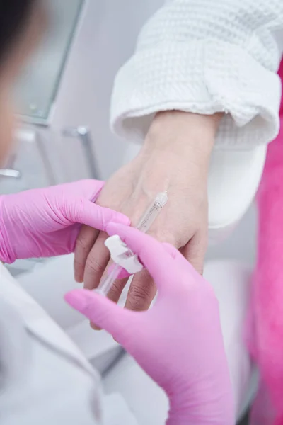Médico de beleza fazendo injeção anti envelhecimento no braço para o cliente masculino — Fotografia de Stock
