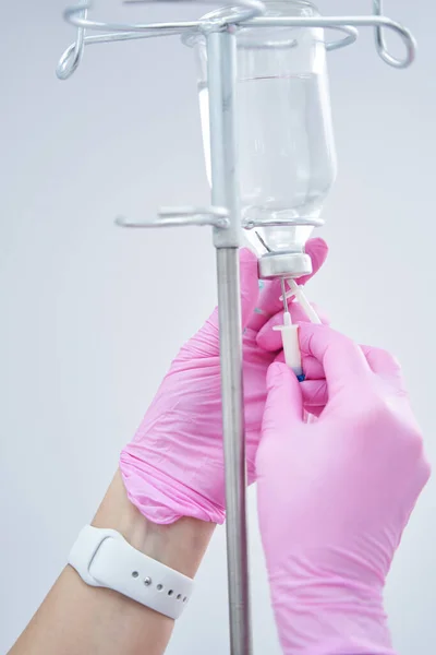 Foto de cerca de manos cosmetólogas fijando infusión IV para el cliente — Foto de Stock