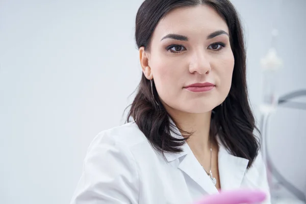 Vårdande kosmetolog kvinnlig njuter av att arbeta på skönhetskliniken — Stockfoto