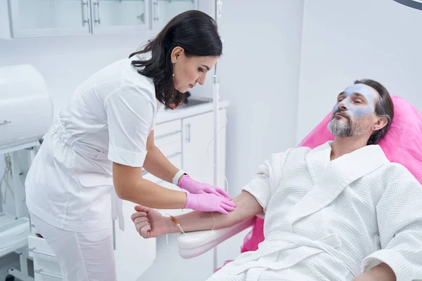 Baard mannelijke klant rusten en het krijgen van een intraveneuze infusie in spa salon — Stockfoto