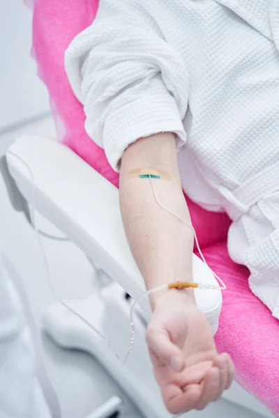 Cliente masculino em roupão branco recebendo infusão IV profissional na clínica — Fotografia de Stock