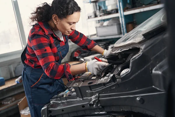 Giovane meccanico femminile attento riparazione motore auto — Foto Stock