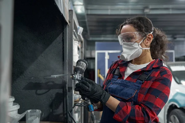 Mecânico feminino atento usando compressor de pulverização para o trabalho — Fotografia de Stock