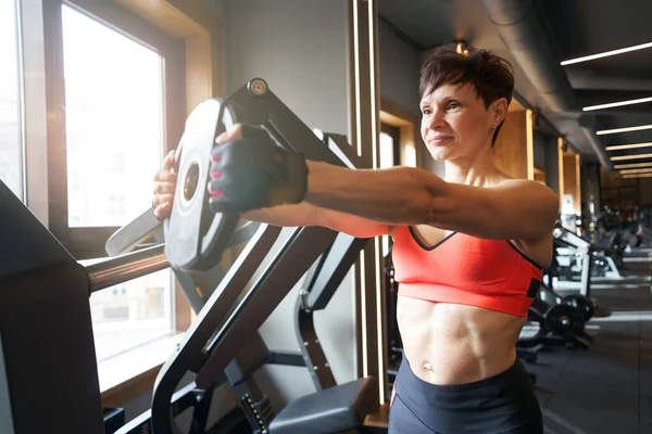 Kvinnlig Kroppsbyggare Håller Vikter Med Utsträckta Armar Framåt Styrketräning — Stockfoto