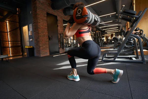 Profesyonel Bayan Atlet Omuzlarının Üzerinden Ağır Bir Torbayla Ileri Atlama — Stok fotoğraf