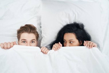 Yatakta endişeli bir adamın yanında yatan ve ona bakan kadın manzarası.