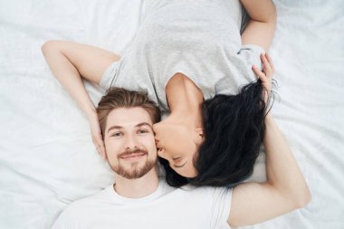 Genç bir bayanı yatakta sevgilisini öperken görmek çok güzel.