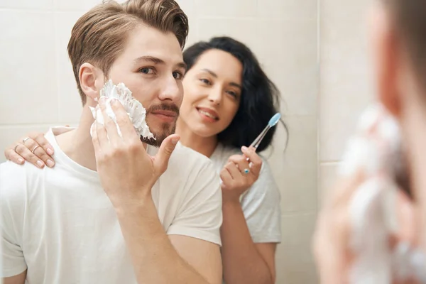 Hombre Enfocado Aplicando Espuma Afeitar Cara Presencia Complacido Compañero Femenino — Foto de Stock