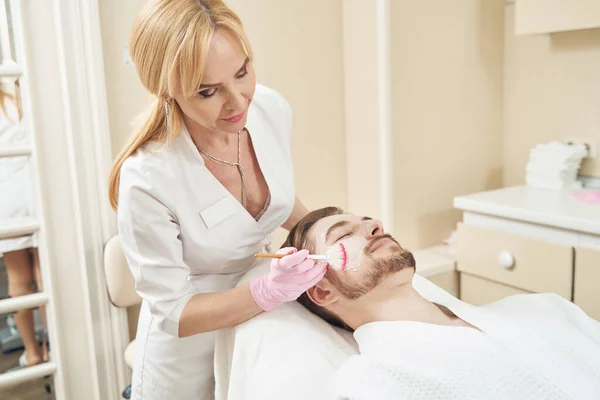 Vrouwelijke Cosmetoloog Achter Liggende Patiënt Doen Schoonheid Masker Procedure Het — Stockfoto