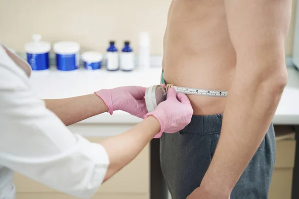 美容师用测量带检查美容外科门诊部的白种人男性胃大小 — 图库照片