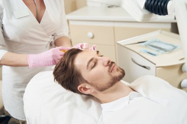 Güzellik kliniği çalışanı, insan beyninin sol tarafına güzellik aşısı yapıyor. Deri tedavisi ve gençleştirme için.