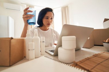 Masada oturmuş dizüstü bilgisayar ekranına bakan ciddi odaklanmış bir işveren.