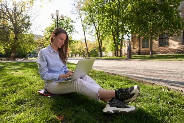Spokojna Kobieta Smartfonem Siedzi Trawie Pisze Laptopie Słoneczny Dzień Świeżym — Zdjęcie stockowe