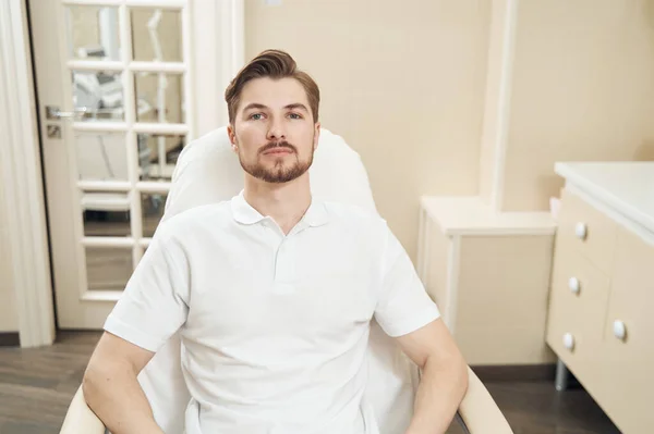Young Caucasian Man Armchair Beauty Center Staring Camera — Stock Photo, Image