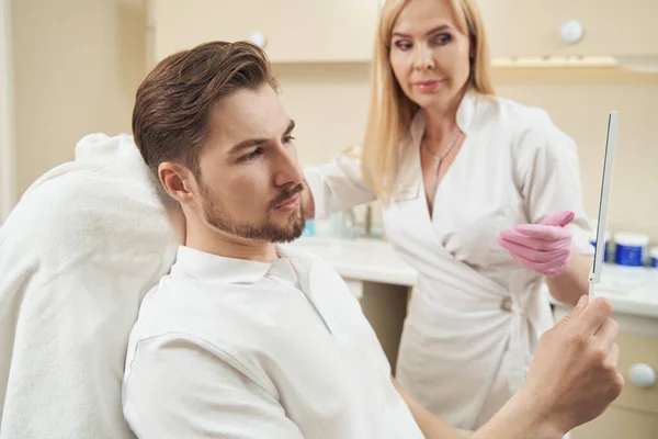 Joven Visitante Masculino Caucásico Centro Belleza Mirando Cara Espejo Junto — Foto de Stock