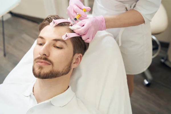 美の専門家は 皮膚のしわの除去のためのボツリヌス毒素で男性の頭を注入 — ストック写真